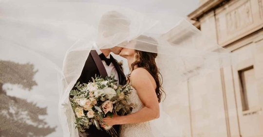 A husband and wife sharing their first kiss at a wedding