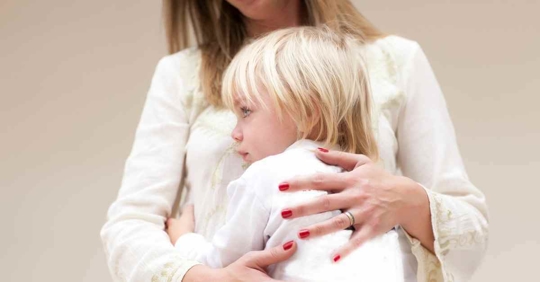 A young child hugging their mother