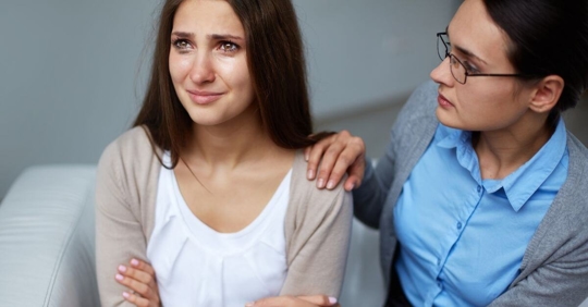 A woman consoling her friend who is crying