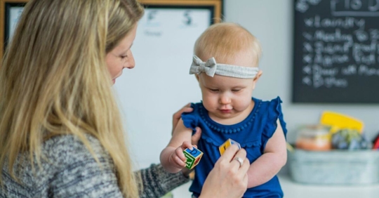 A woman playing with her baby daughter