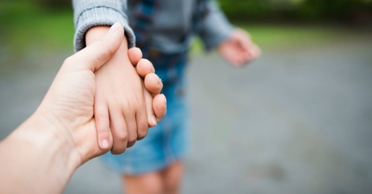 close up of a parent holding their child's hand