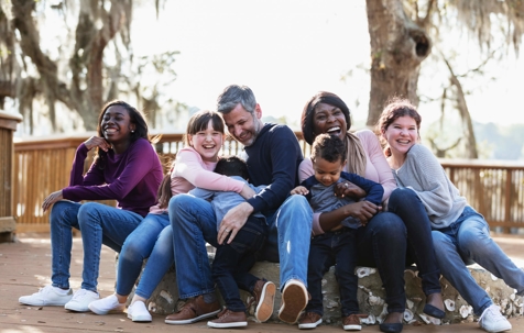 Parents and five kids sitting on bench