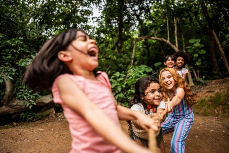 children playing tug of war in the woods