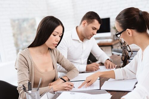 Couple signing prenuptial agreement